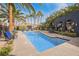 Community pool area surrounded by palm trees, lounge chairs, and lush landscaping at 9050 W Tropicana Ave # 1178, Las Vegas, NV 89147