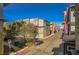 Street view of colorful urban condo community with trees, street parking and blue sky at 9050 W Tropicana Ave # 1178, Las Vegas, NV 89147