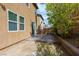 Backyard with a concrete patio, mature landscaping, and a retaining wall at 9445 Sweetwood Ave, Las Vegas, NV 89149