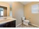 Bathroom showcasing a vanity with dark wood cabinets and a sink, adjacent to a toilet and framed mirror at 9445 Sweetwood Ave, Las Vegas, NV 89149