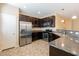 Well-equipped kitchen featuring stainless steel appliances, granite countertops, and dark wood cabinetry at 9445 Sweetwood Ave, Las Vegas, NV 89149