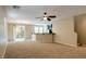 Open living area with ceiling fan, bar, sliding glass door to the patio, and staircase access at 9445 Sweetwood Ave, Las Vegas, NV 89149
