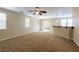 Spacious living room with plush carpeting, ceiling fan, and a sliding glass door to the backyard at 9445 Sweetwood Ave, Las Vegas, NV 89149