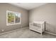 Neutral Bedroom showcases a window with shutters and a white crib on soft carpet at 10086 Mountain Foothills Ave, Las Vegas, NV 89149