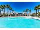 Resort-style community pool surrounded by palm trees and shaded lounge area, perfect for relaxation at 10341 Birch Bluff Ln, Las Vegas, NV 89145