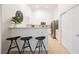 Well-lit kitchen featuring white cabinets, stainless steel appliances, a breakfast bar, and tile flooring at 10341 Birch Bluff Ln, Las Vegas, NV 89145