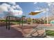 Community playground featuring swings, a play structure, shade structures, and a grassy area at 11242 Almador Vista Ct, Las Vegas, NV 89135