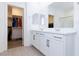 Bright bathroom with double sink vanity, large mirror, tile floors, and a walk-in closet at 11439 Peak Landing Ave, Las Vegas, NV 89138