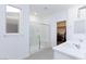Bright bathroom with double sink vanity, shower with bench, tile floors, and a white color palette at 11439 Peak Landing Ave, Las Vegas, NV 89138