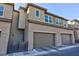 Two-story townhouse featuring attached garages, neutral exteriors and a paved walkway at 11439 Peak Landing Ave, Las Vegas, NV 89138