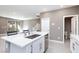 Bright kitchen with stainless steel appliances, white cabinets, island with sink, and quartz countertops at 11439 Peak Landing Ave, Las Vegas, NV 89138
