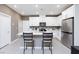 Modern white kitchen with stainless steel appliances, a central island, and bar seating at 11439 Peak Landing Ave, Las Vegas, NV 89138
