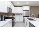 Bright kitchen with stainless steel appliances, white cabinets, tile floor, and quartz countertops at 11439 Peak Landing Ave, Las Vegas, NV 89138