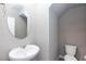Clean powder room with pedestal sink, oval mirror, tiled floor, and neutral paint at 11439 Peak Landing Ave, Las Vegas, NV 89138