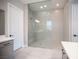 Modern bathroom with large frameless glass shower and gray cabinets at 11701 Hatchling Ave, Las Vegas, NV 89138