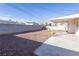 Large backyard area with gravel, patio, covered area, and block wall fence at 119 Cedar St, Henderson, NV 89015