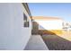 Side exterior view of a white home with a security door and rock landscaping at 119 Cedar St, Henderson, NV 89015