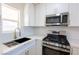 Updated kitchen with white cabinets, quartz countertops, and stainless steel appliances at 119 Cedar St, Henderson, NV 89015