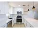 Bright kitchen features white cabinets, stainless steel appliances, and modern pendant lights at 119 Cedar St, Henderson, NV 89015