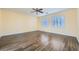 Sunny yellow bedroom with hardwood floors, ceiling fan, and shuttered windows for a bright and airy space at 12254 La Prada Pl, Las Vegas, NV 89138