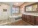 This luxurious bathroom features a soaking tub, glass shower, double vanity, and wood cabinets at 1276 Spanish Armada Rd, Las Vegas, NV 89123