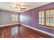 A spacious bedroom features wood floors, two shuttered windows, and a fresh coat of bright paint at 1276 Spanish Armada Rd, Las Vegas, NV 89123