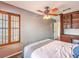This bedroom features a ceiling fan, a built-in cabinet with a desk area and light gray walls at 1276 Spanish Armada Rd, Las Vegas, NV 89123