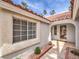 Inviting entryway with a decorative window, red brick accents and a covered porch at 1276 Spanish Armada Rd, Las Vegas, NV 89123