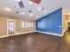 Spacious living room with high ceilings, wood-look flooring, and a pop of blue accent wall at 1276 Spanish Armada Rd, Las Vegas, NV 89123
