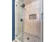 A shower stall features large marble-style tiles, black fixtures, and a built-in soap niche at 1276 Spanish Armada Rd, Las Vegas, NV 89123