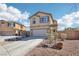 Inviting two-story home featuring a well-manicured lawn, desert landscaping, and an attached two-car garage at 145 Blue Trout Ave, Henderson, NV 89011