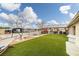 Exterior shot of backyard featuring grass lawn, outdoor dining area and a bright sky with clouds at 1550 Tiptop Trl, Pahrump, NV 89048