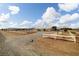 Rural property featuring a sprawling ranch-style home, gravel driveway, and white fencing at 1550 Tiptop Trl, Pahrump, NV 89048