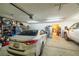 Spacious garage with ample storage space, featuring multiple cars and an additional refrigerator at 1550 Tiptop Trl, Pahrump, NV 89048