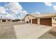 Exterior view of a spacious driveway leading to an attached two-car garage and storage sheds at 1550 Tiptop Trl, Pahrump, NV 89048