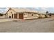 Wide shot of the exterior featuring a driveway leading to a two-car garage and car port at 1550 Tiptop Trl, Pahrump, NV 89048