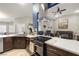 Open kitchen has stainless hood vent, dark cabinets, and flows into the living room at 1550 Tiptop Trl, Pahrump, NV 89048