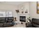 Inviting living room showcasing a stone fireplace, large window, and comfortable seating at 1550 Tiptop Trl, Pahrump, NV 89048