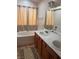 Bright bathroom with a double sink vanity and a separate soaking tub with shower curtains at 1900 E Highland Ave, Pahrump, NV 89048
