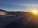 Scenic exterior view of a home at sunset, featuring mountain views and desert landscaping at 1900 E Highland Ave, Pahrump, NV 89048
