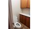 Convenient half bathroom with wooden cabinets, a white countertop, and tile flooring at 1900 E Highland Ave, Pahrump, NV 89048
