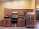 Efficient kitchen with wooden cabinets, stainless steel appliances, and tile countertops at 1900 E Highland Ave, Pahrump, NV 89048