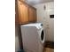Stacked washer and dryer with cabinetry, and a door leading to the outside at 1900 E Highland Ave, Pahrump, NV 89048