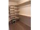 Well-organized walk-in closet with ample shelving, wooden rods, and carpet flooring at 1900 E Highland Ave, Pahrump, NV 89048
