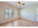Light-filled bedroom with two windows, neutral walls, ceiling fan and tiled floor at 2715 Riceville Dr, Henderson, NV 89052