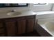 Bathroom featuring a vanity, bathtub with tiled surround, and dark wood-look floors at 3231 Comitan Ln, Las Vegas, NV 89122