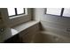 Bathroom featuring a built-in bathtub with tiled surround and vanity with storage at 3231 Comitan Ln, Las Vegas, NV 89122