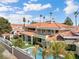 The backyard of the house features a pool with palm trees around it, a terrace and desert landscaping at 42 Sawgrass Ct, Las Vegas, NV 89113