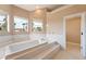 Elevated soaking tub with marble surround and views of palm trees at 42 Sawgrass Ct, Las Vegas, NV 89113