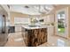 Spacious kitchen features a large island with cooktop, stainless steel appliances, and an adjacent view to backyard at 42 Sawgrass Ct, Las Vegas, NV 89113